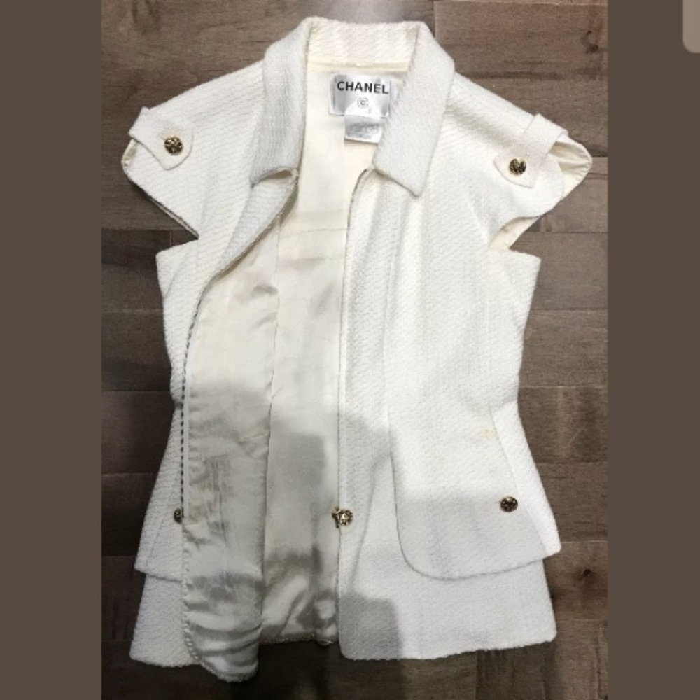 White Chanel vest with gold accents.
